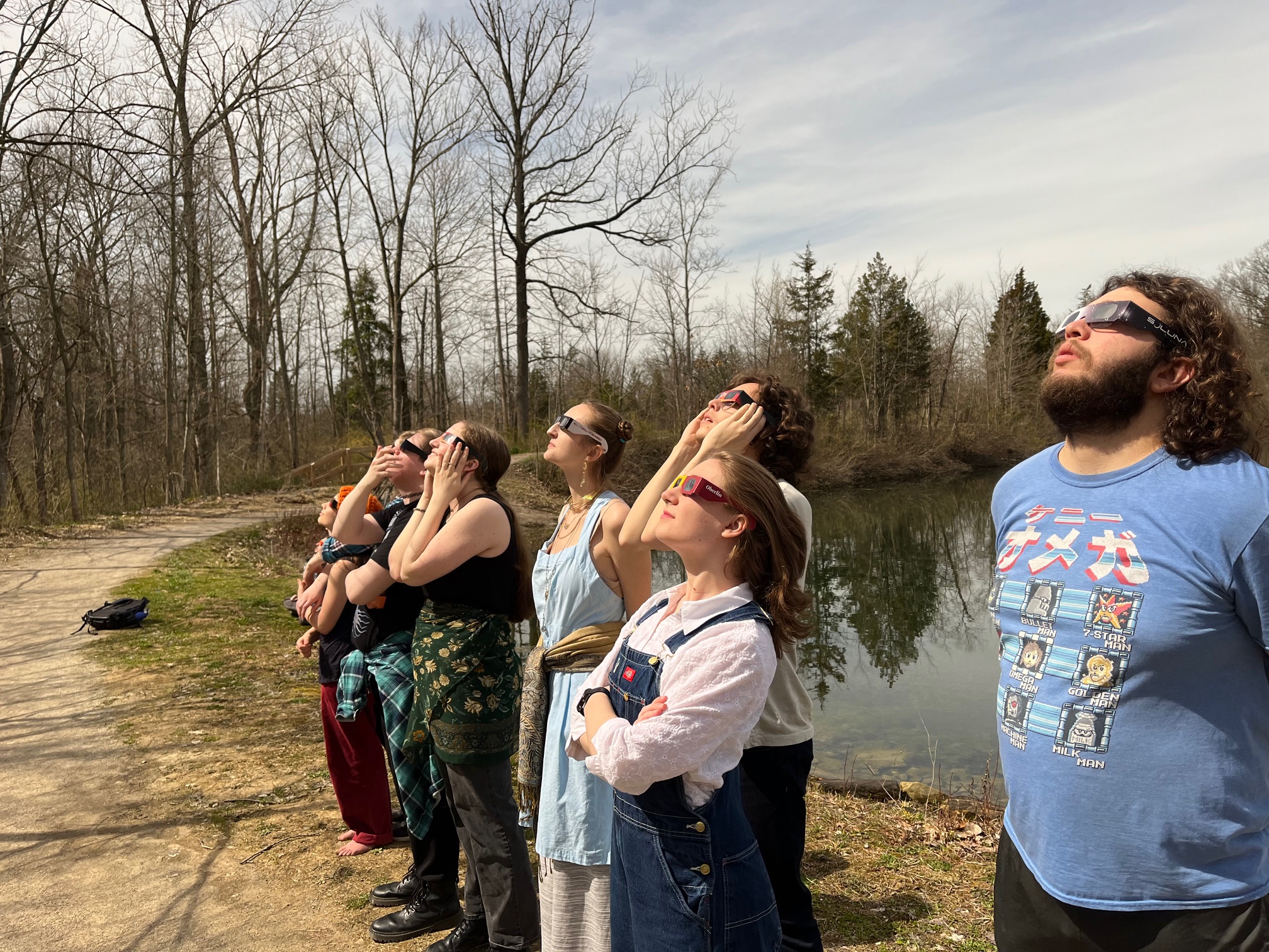 A group of Obies wearing eclipse glasses, looking skyward